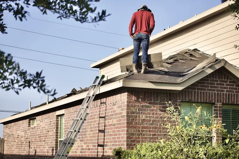Professional roofer working on a residential roof in Kumtux